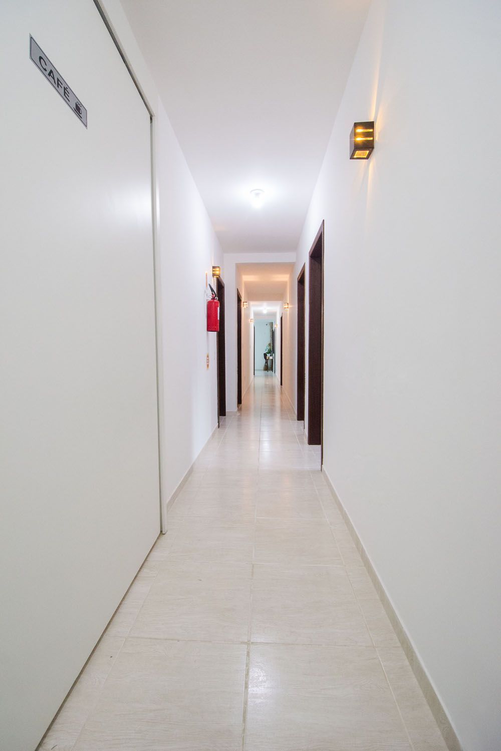 Um longo corredor com um extintor de incêndio na parede