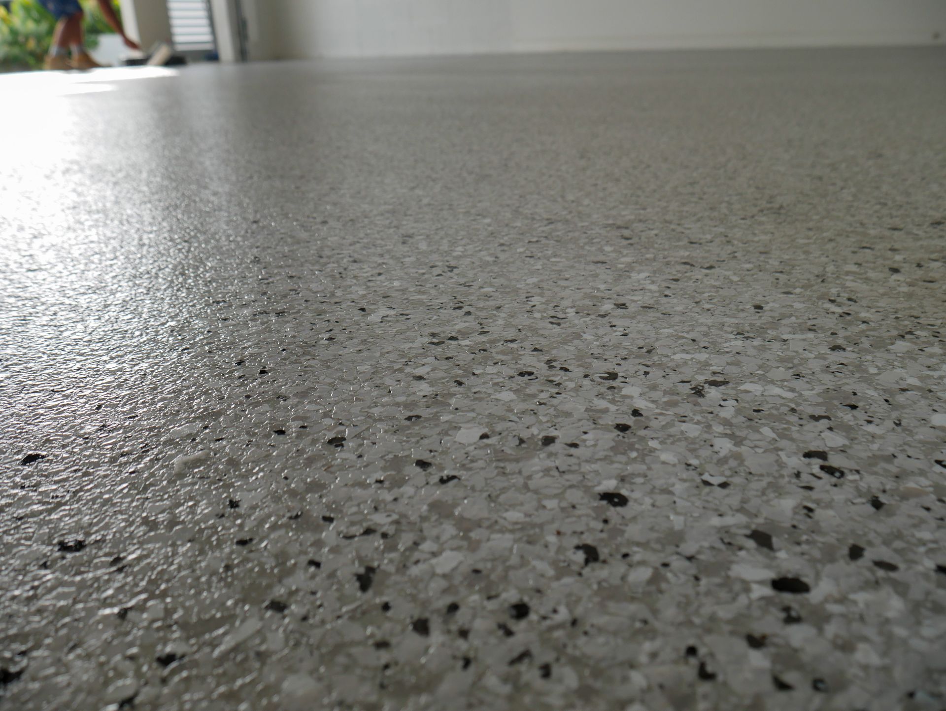 A close up of a white floor with black spots.