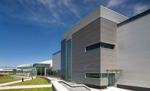 An outside view of the Cordis factory with blue skies and green grass