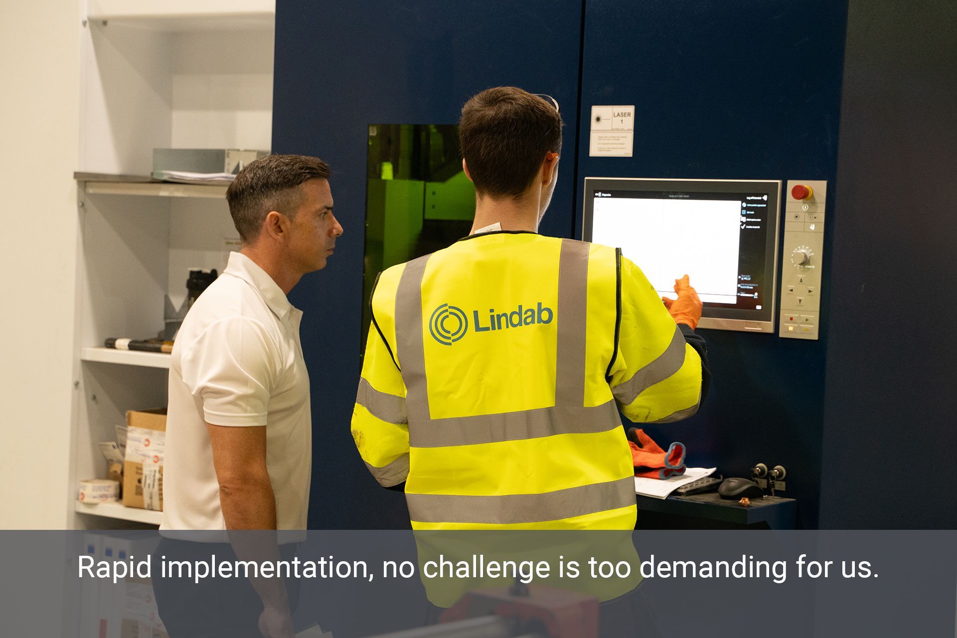 Two A.C. Manufacturing staff looking at the screen on a machine