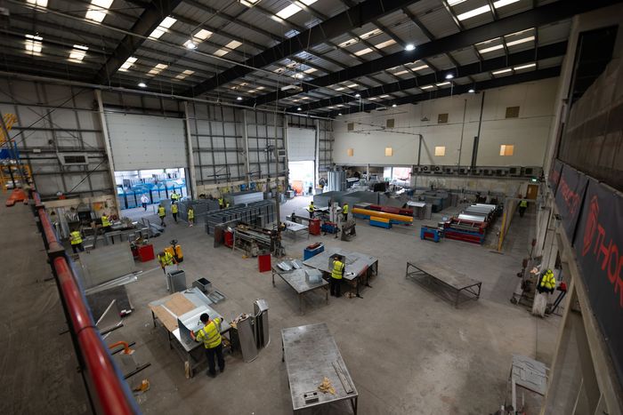 A.C, Manufacturing factory floor with people standing at their work stations