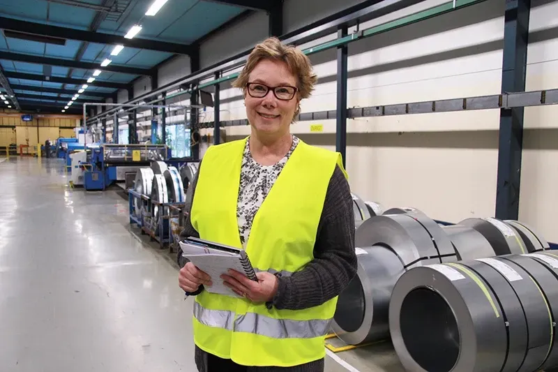 Stina Nordstrom standing on a factory floor in front of steel coils
 