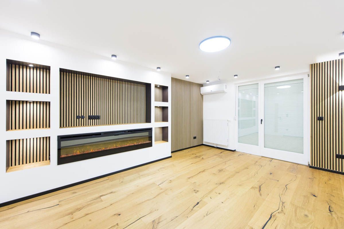 Modernes Wohnzimmer mit Holzböden, Kamin und getäfelter Wand.