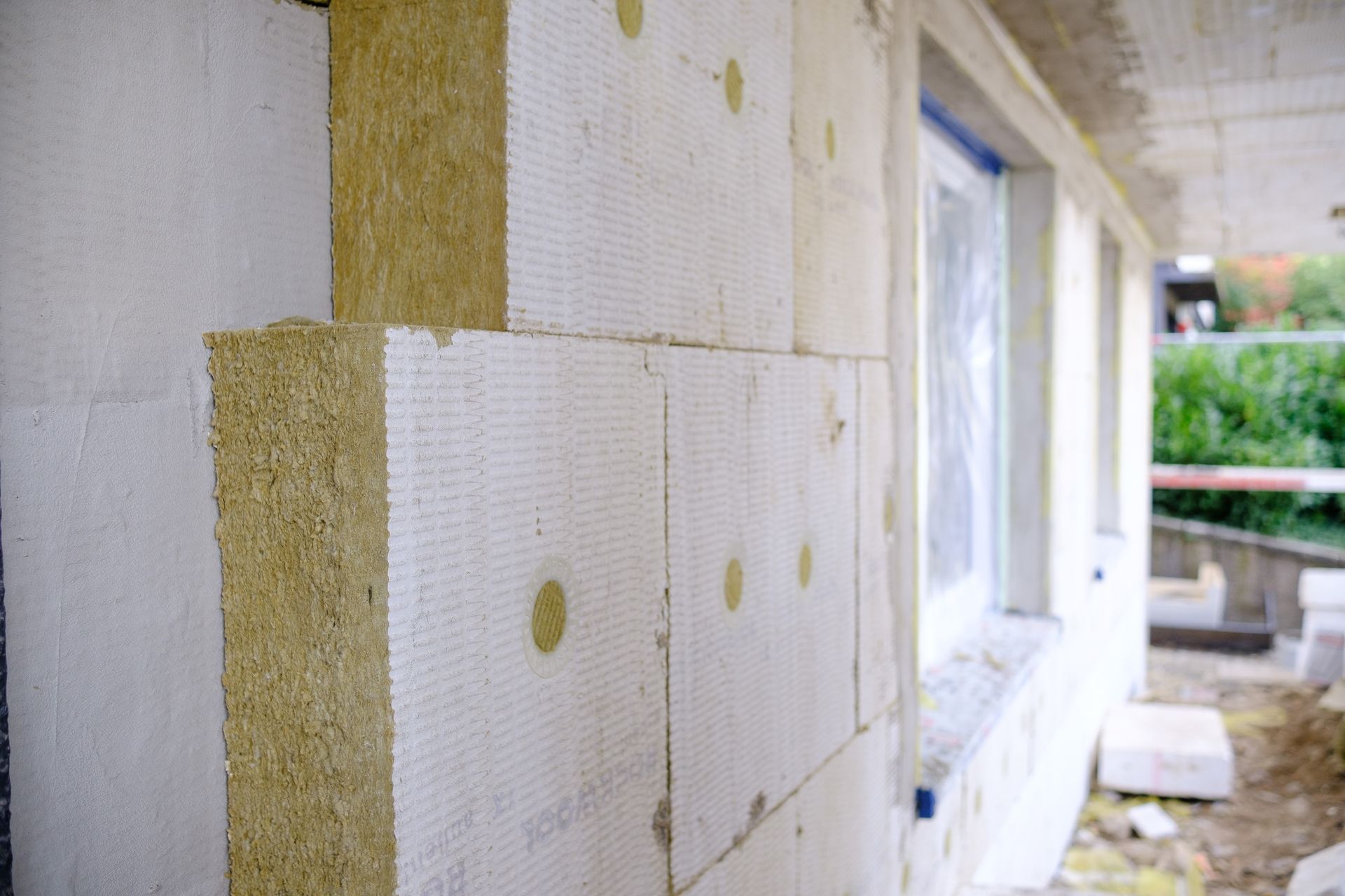 Außenwandkonstruktion mit Dämmblöcken; beige, weiß und grün.