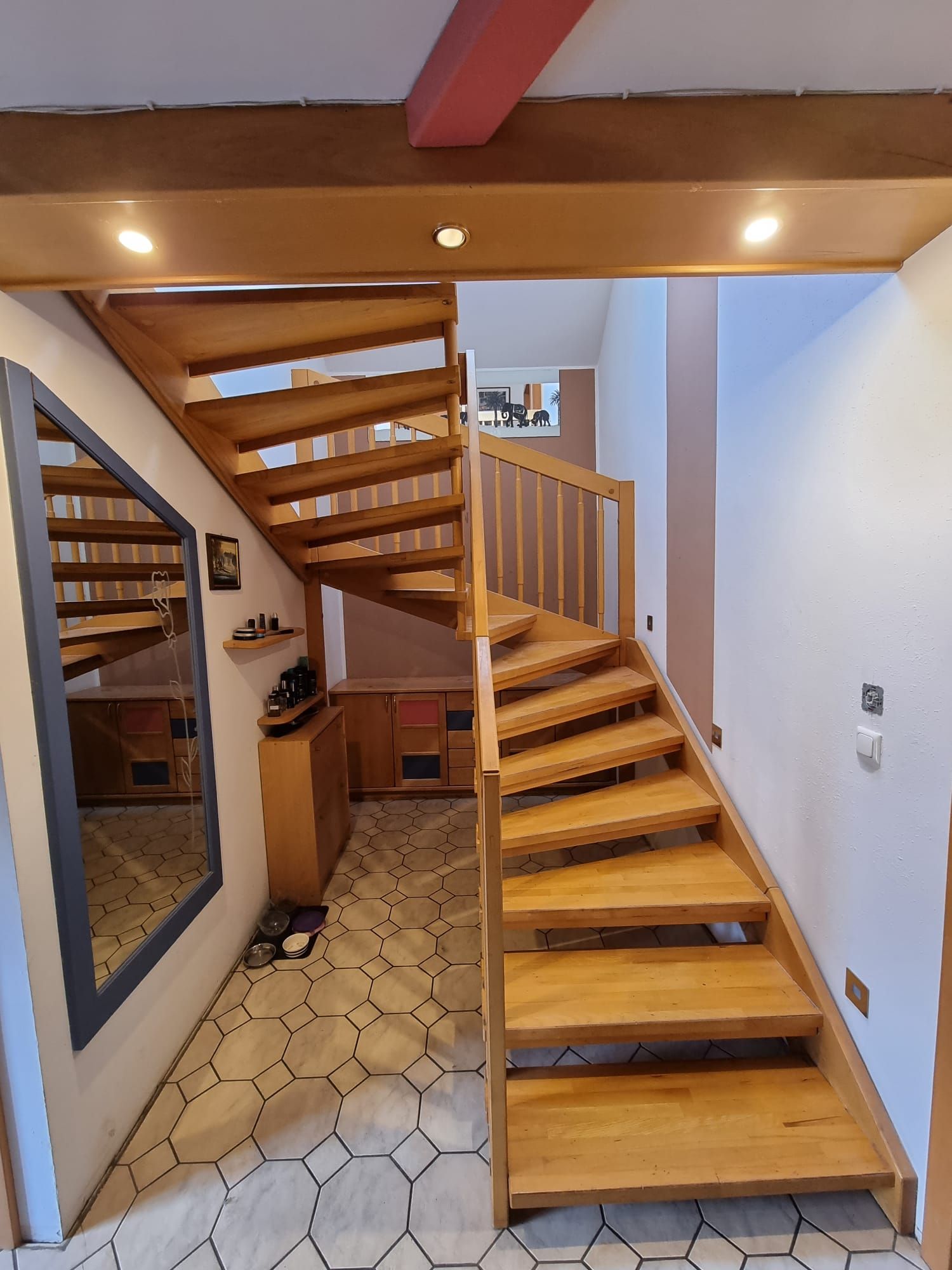 Holztreppe in einem Haus mit hellem Holz und hellbraunen Wänden, die nach oben führt.