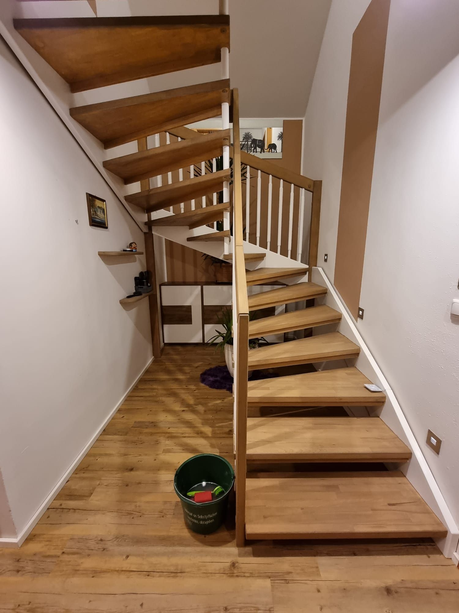 Holztreppe in einem Haus, die nach oben führt. Zeigt Treppen, Handläufe und einen kleinen Treppenabsatz.