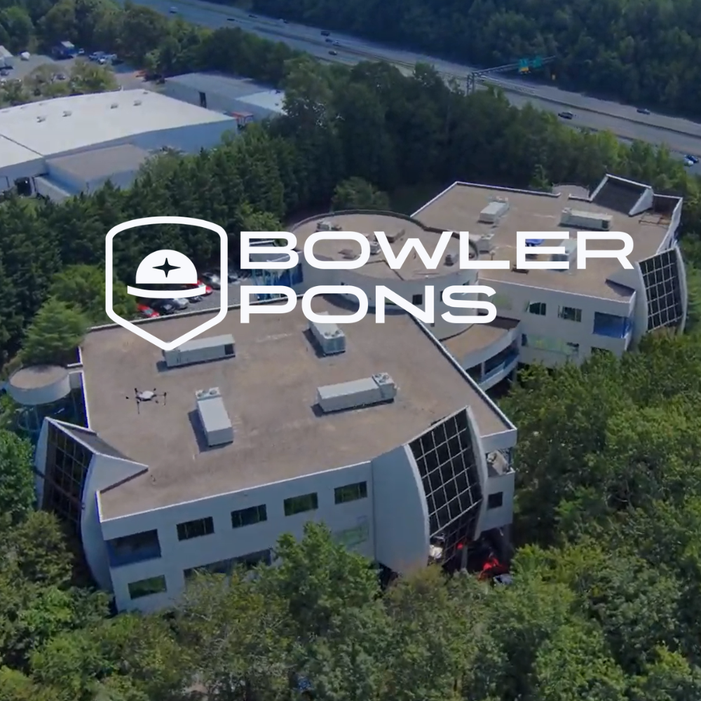 Aerial view of a Bowlers Pons office building surrounded by trees near a road. Bowler Pons Logo on top of image
