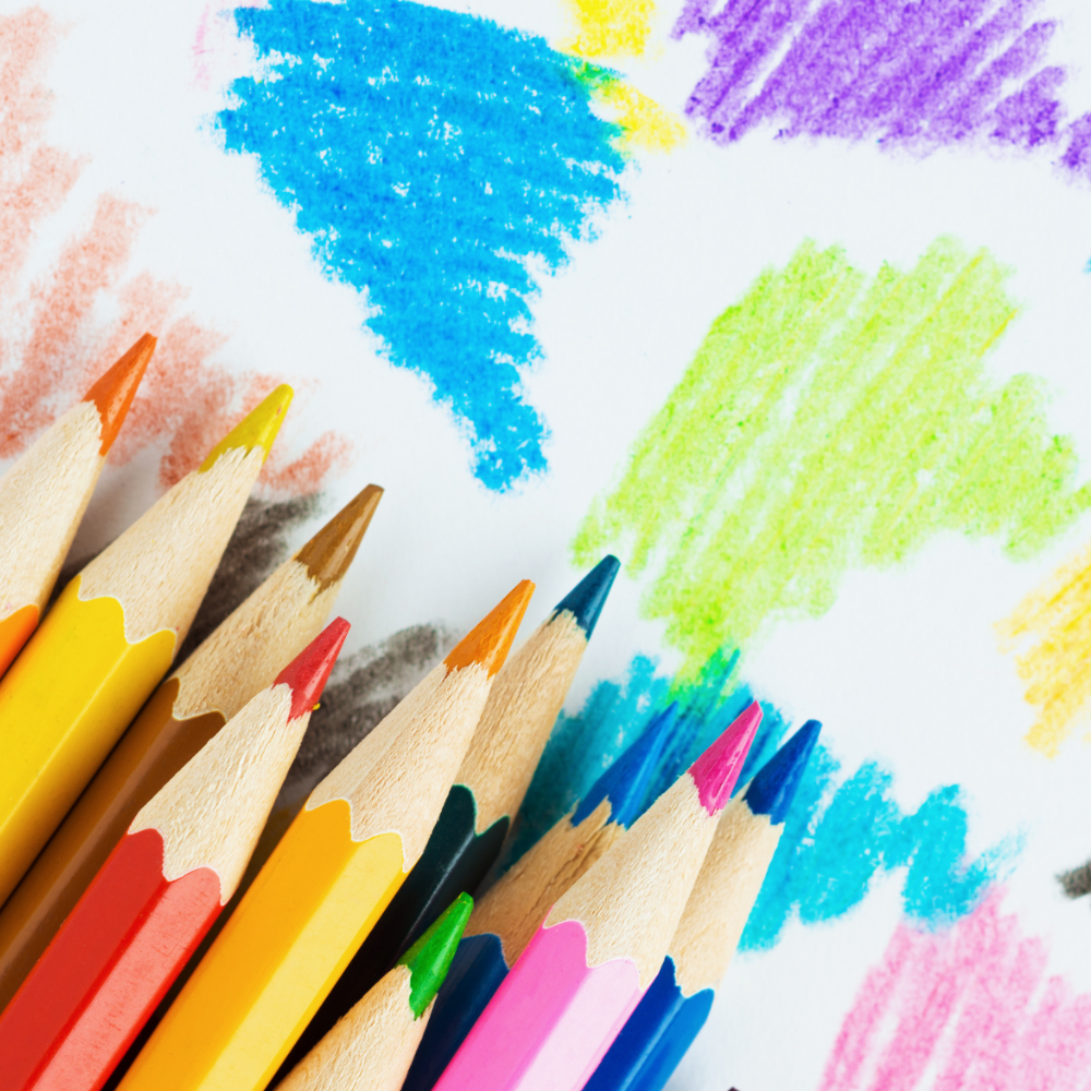 A bunch of colored pencils on top of a drawing