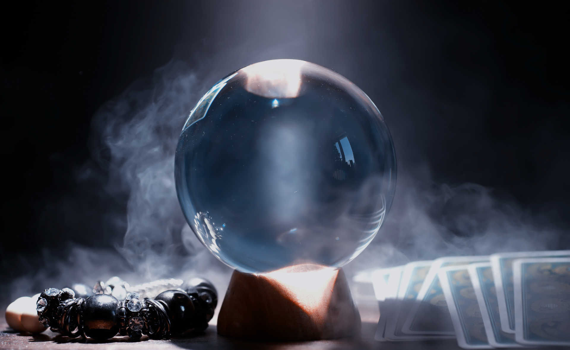 A crystal ball is sitting on top of a wooden pyramid on a table.