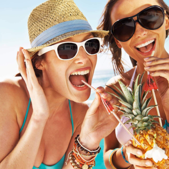 Women drinking cocktails out of coconuts