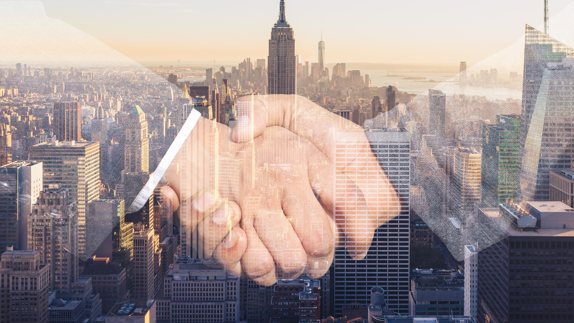 A double exposure of two people shaking hands in front of a city skyline.