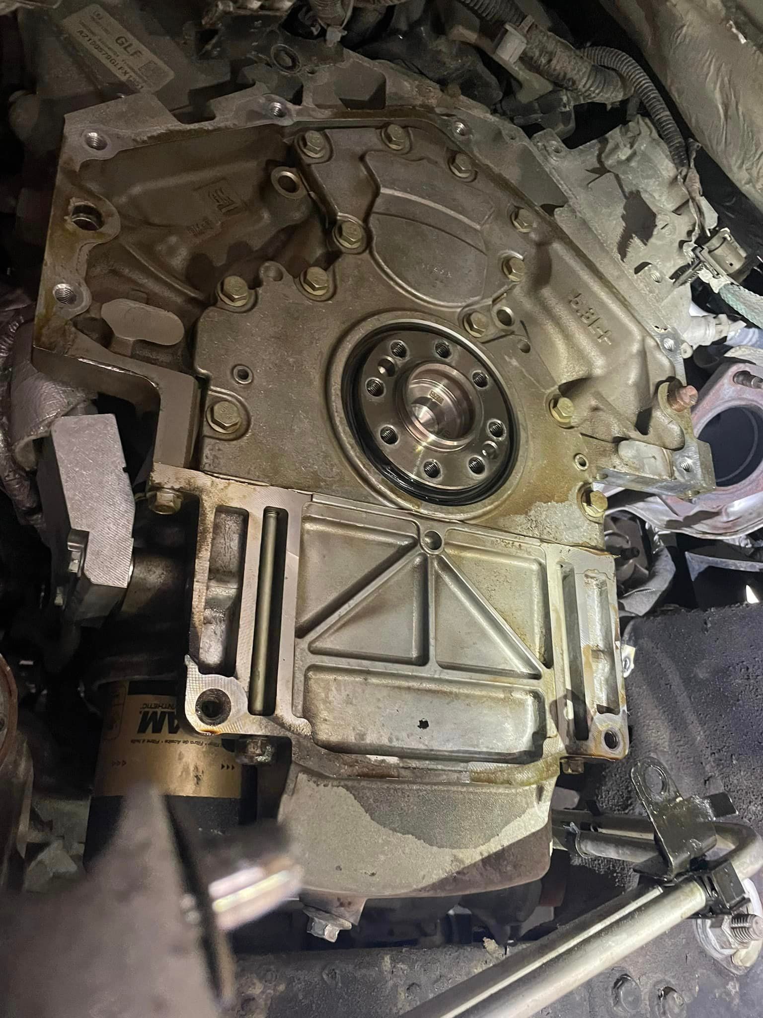 A close up of a car engine with a wrench in it.