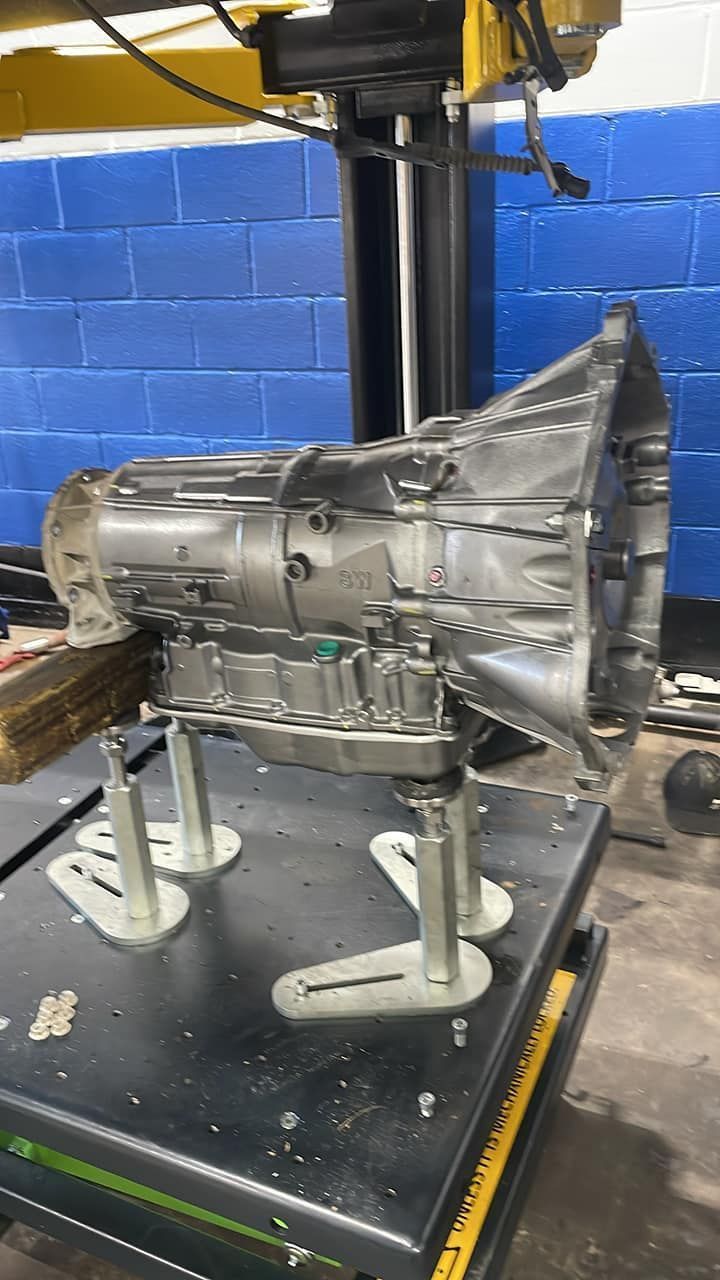 A gearbox is sitting on top of a table in a garage.