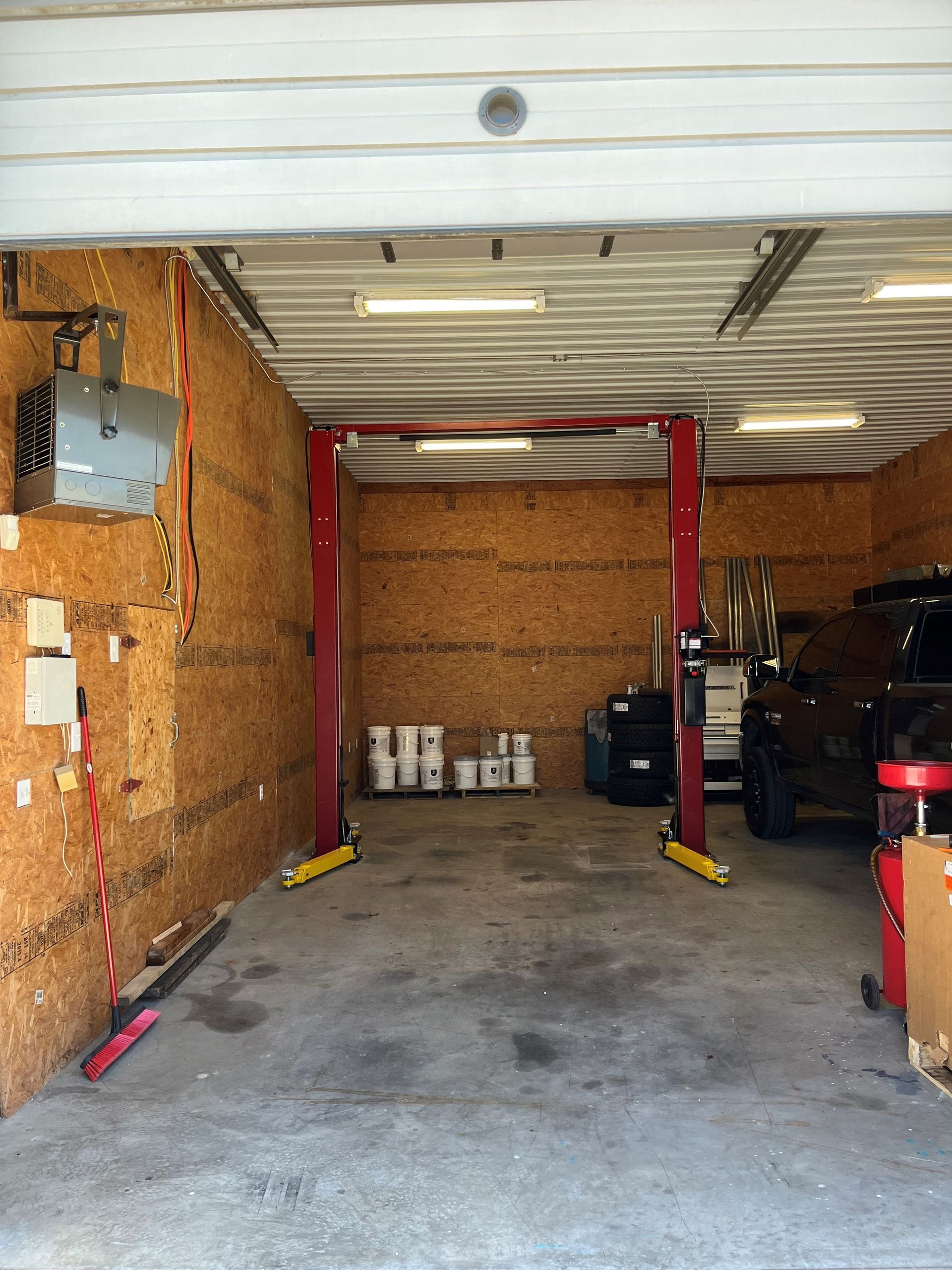 A garage with a red lift in the middle of it