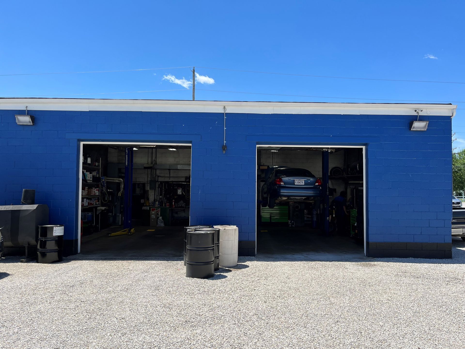A blue brick garage with a car parked inside of it.