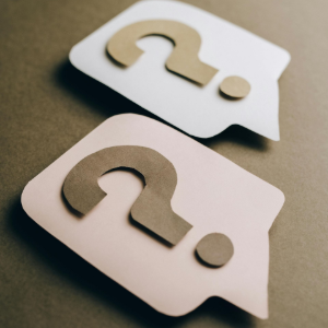 Two speech bubble icons, one white and one pink, on a neutral background