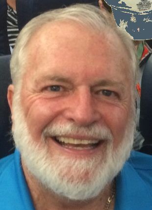Smiling man with white beard and blue shirt.
