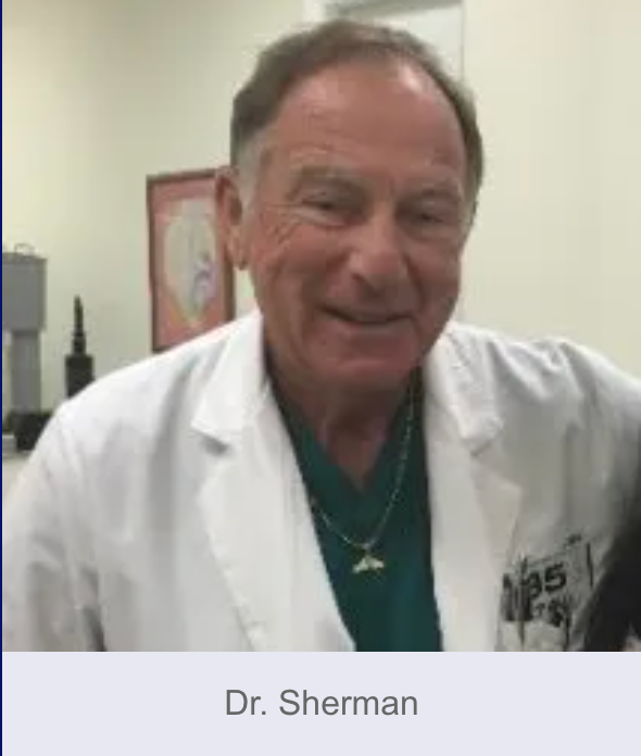 Dr. Sherman smiles, wearing a lab coat over a green top, in what appears to be a medical setting.