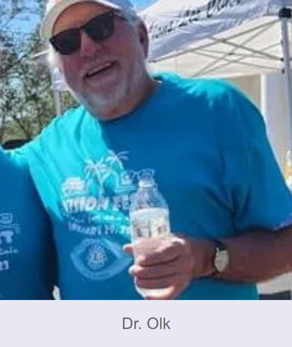 Man wearing sunglasses and a blue t-shirt holding a water bottle, labeled