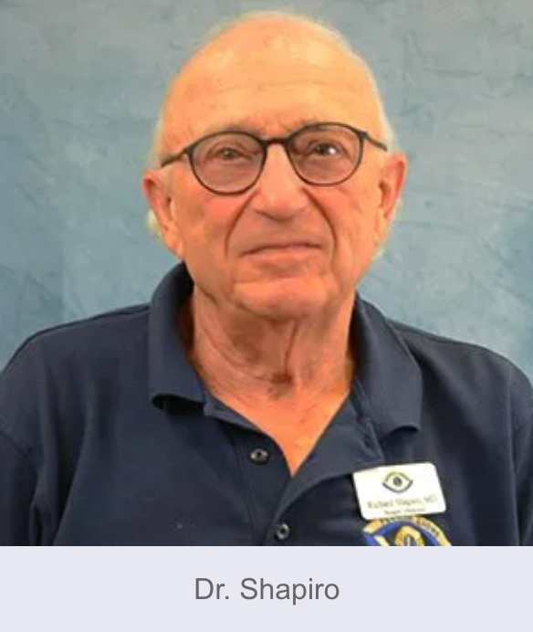 Dr. Shapiro, older man wearing glasses and a blue shirt, smiling slightly.