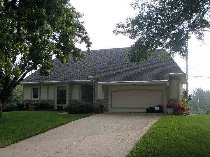 A house with a gray roof and a white garage door