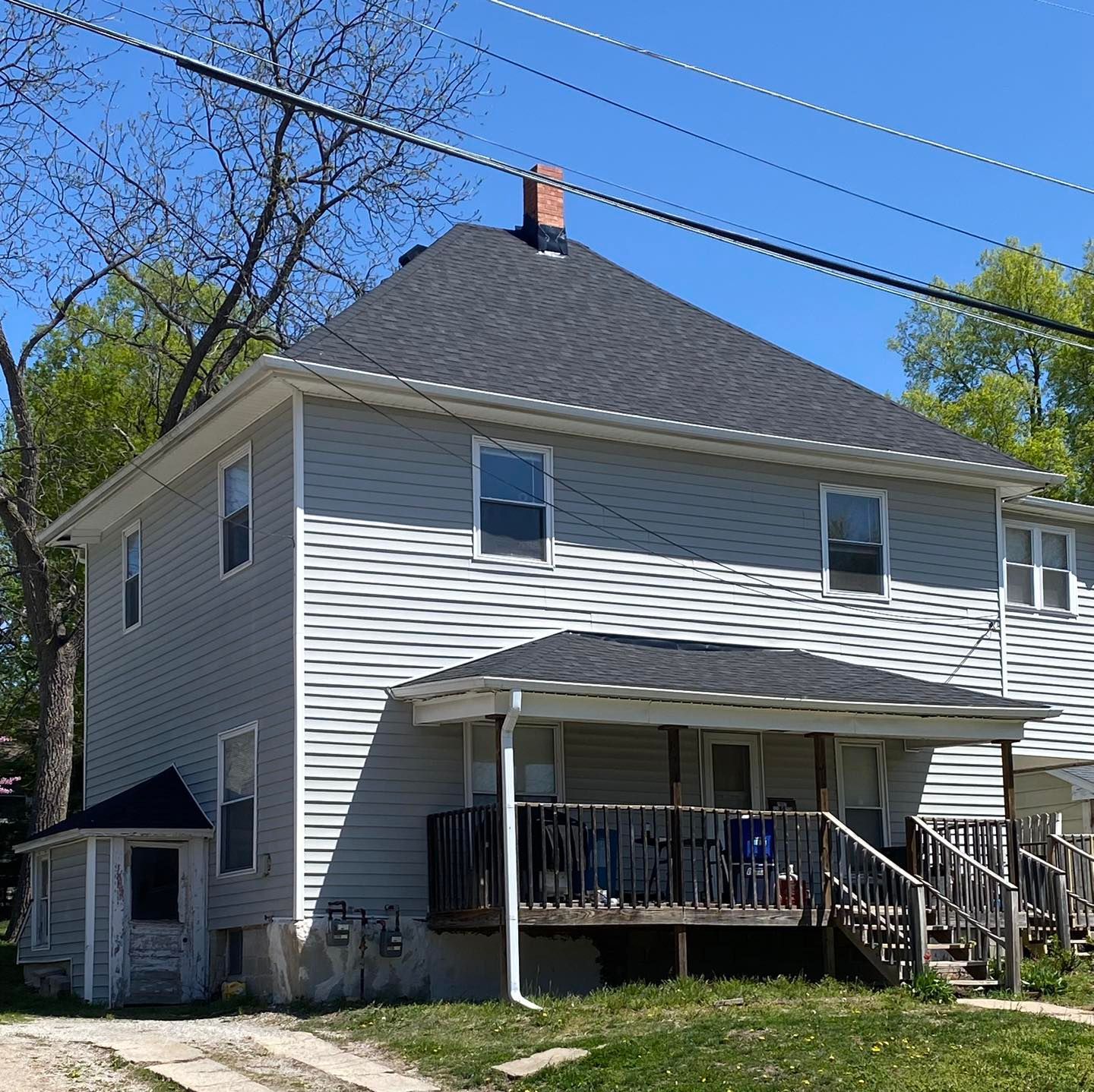A white house with a black roof and a porch