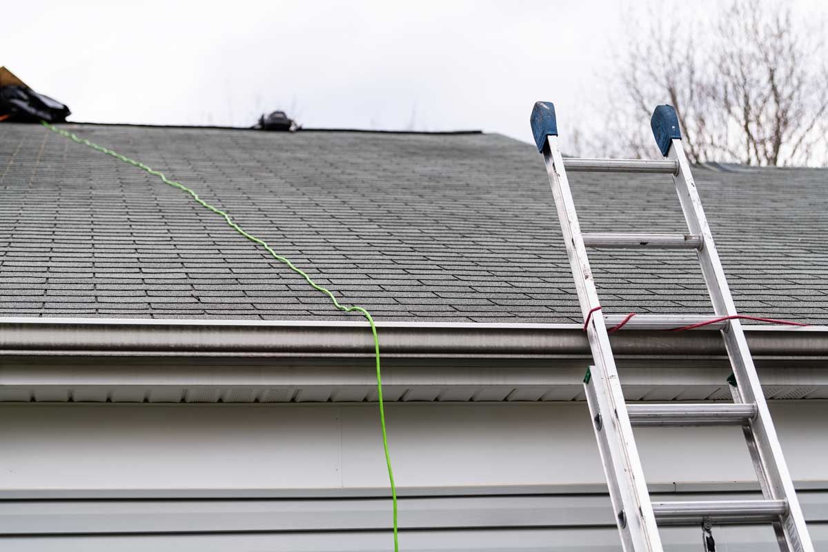 A ladder is attached to the roof of a house