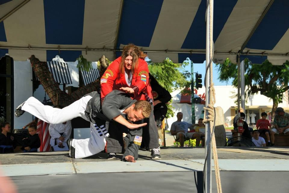 A woman in a red jacket is carrying a man on her shoulders