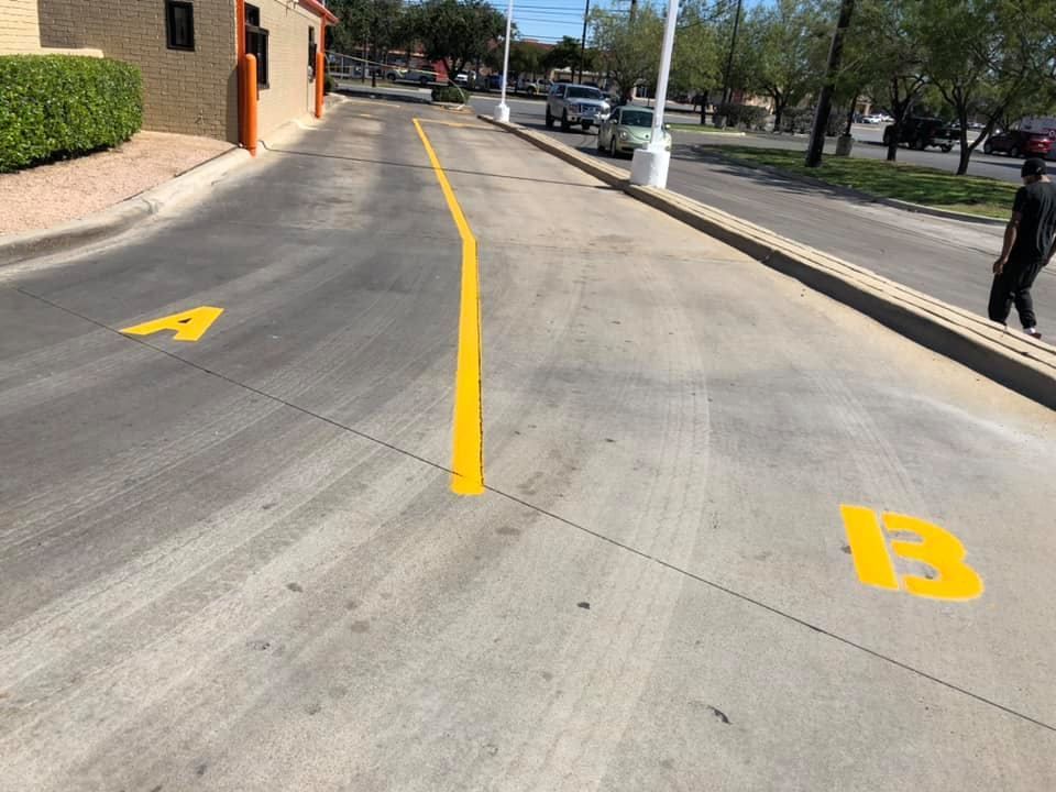 A sidewalk with cars parked on the side of it.
