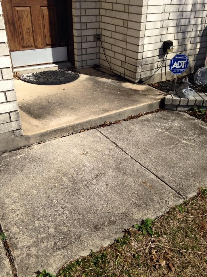 A brick building with a concrete walkway leading to it.