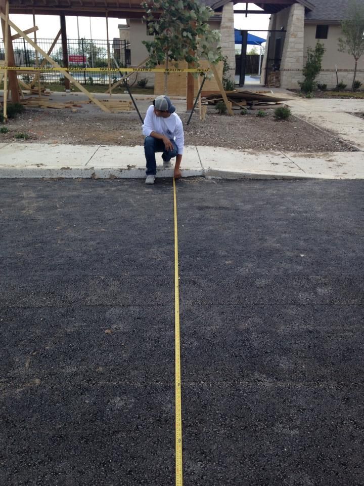 A man is measuring a line with a tape measure