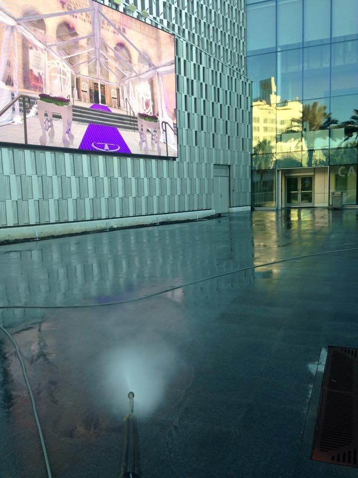 A large screen is hanging on the side of a building