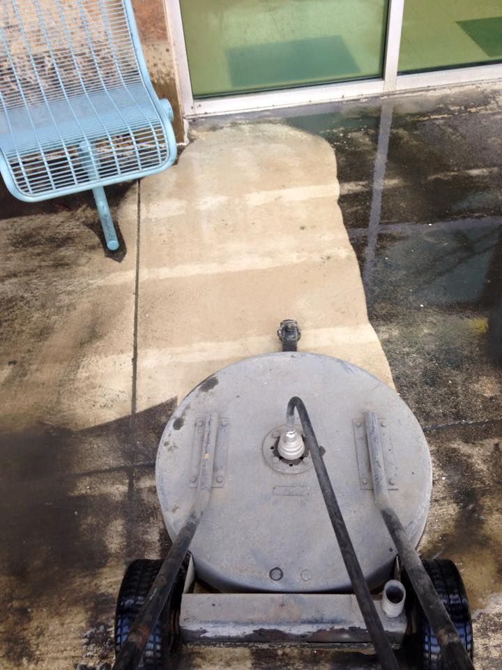 A machine is sitting on a sidewalk next to a chair.