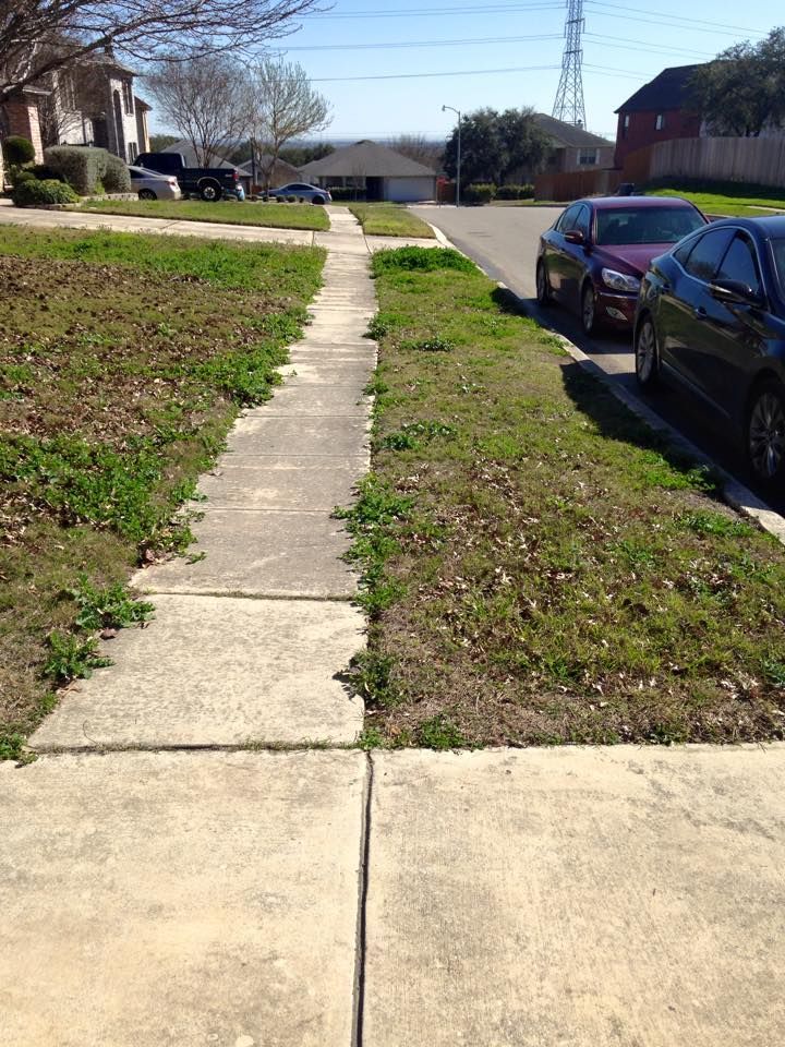 Two cars are parked on the side of the road next to a sidewalk.
