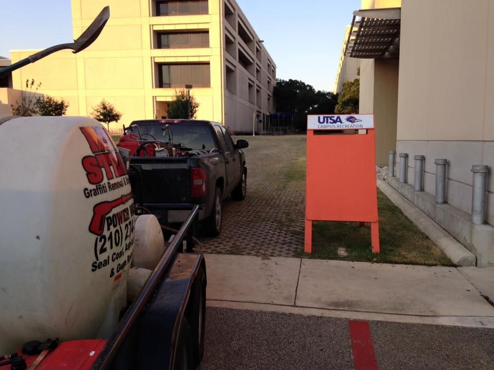 A truck is parked next to an orange sign that says utsa