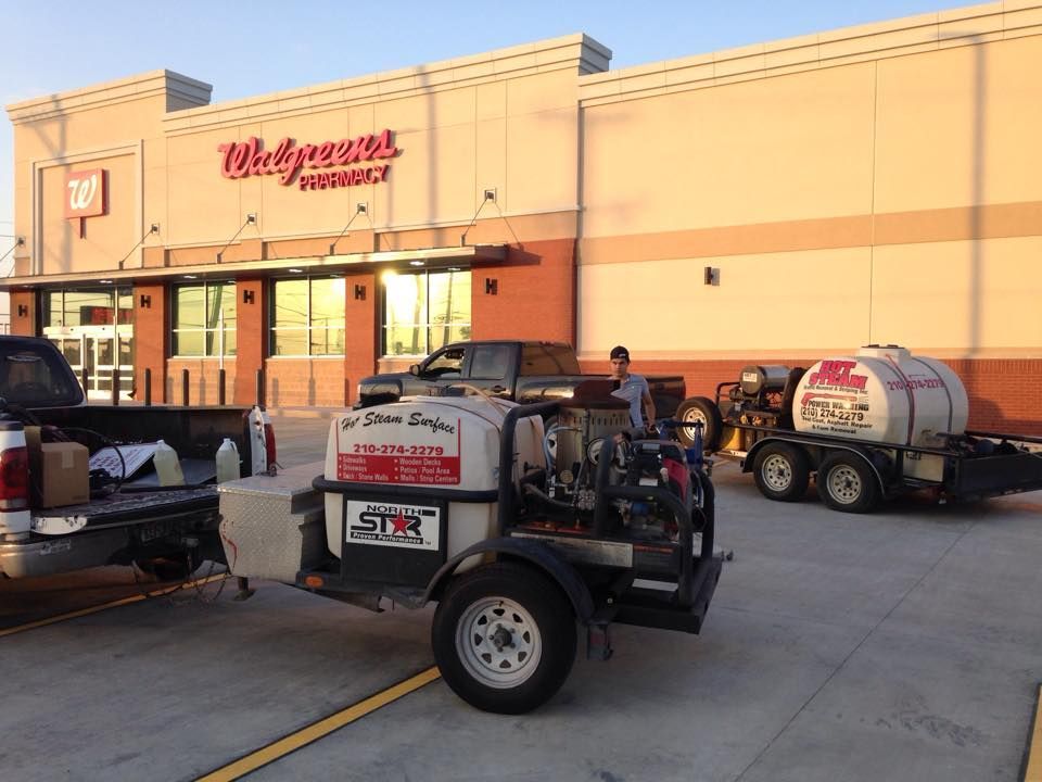 Two trailers are parked in front of a walgreens store