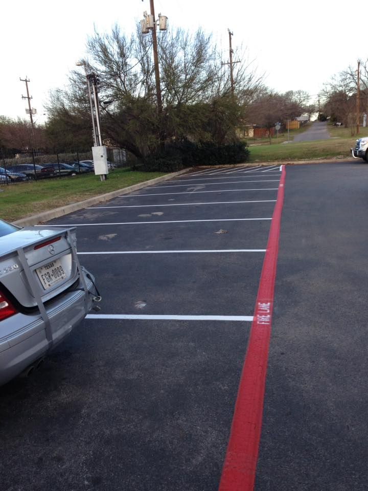 A silver car is parked in a parking lot