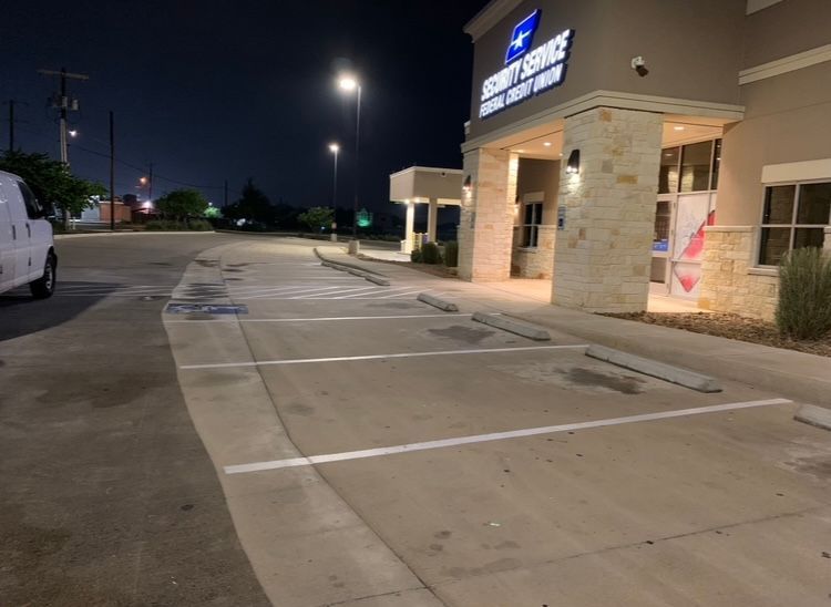 Night exterior of a Security Service Federal Credit Union building with empty parking spaces.