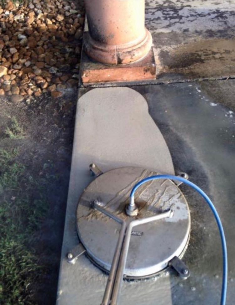 A man is using a machine to paint a parking lot