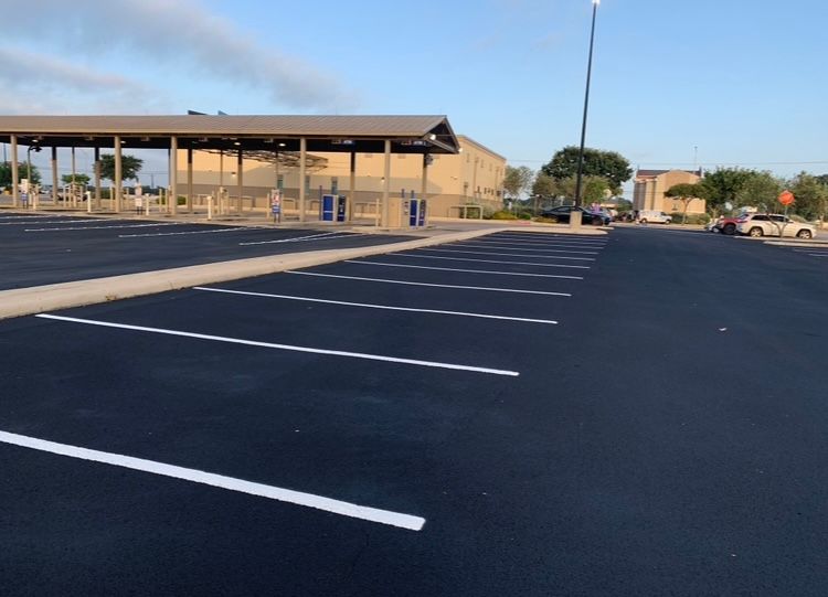 A man is using a machine to paint a parking lot