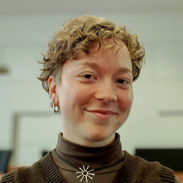 Woman with blonde hair smiling, looking at the camera.