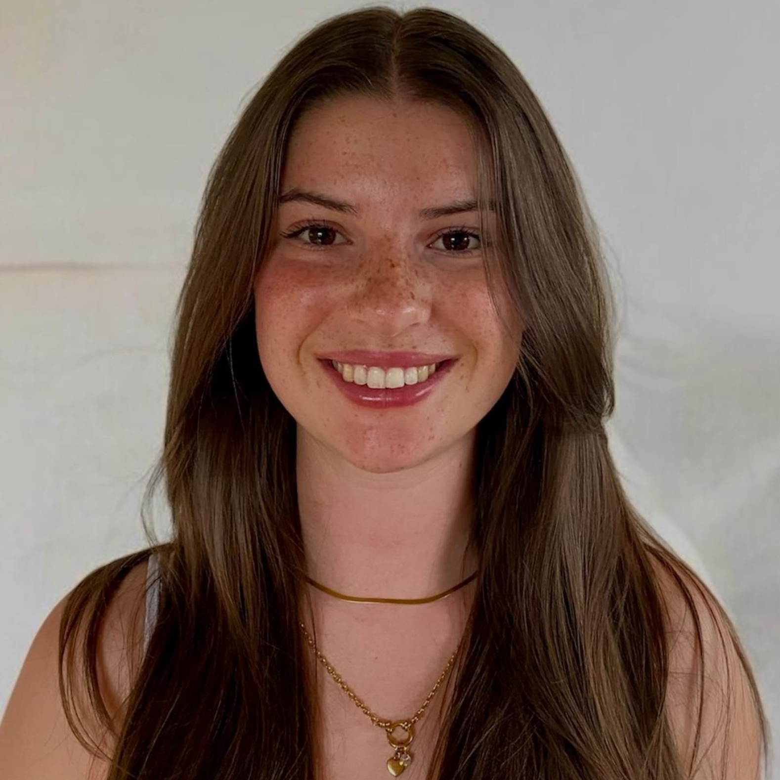 Man in a blue blazer with arms crossed, smiling. Set in an office with a city view.