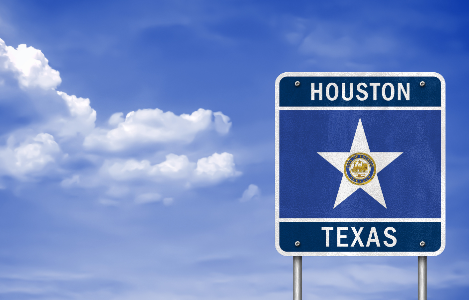 Signpost for Houston, Texas: blue sign with a star, under a cloudy sky.