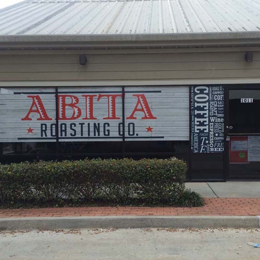 Abita Roasting Co. storefront with red and black lettering on a large window.