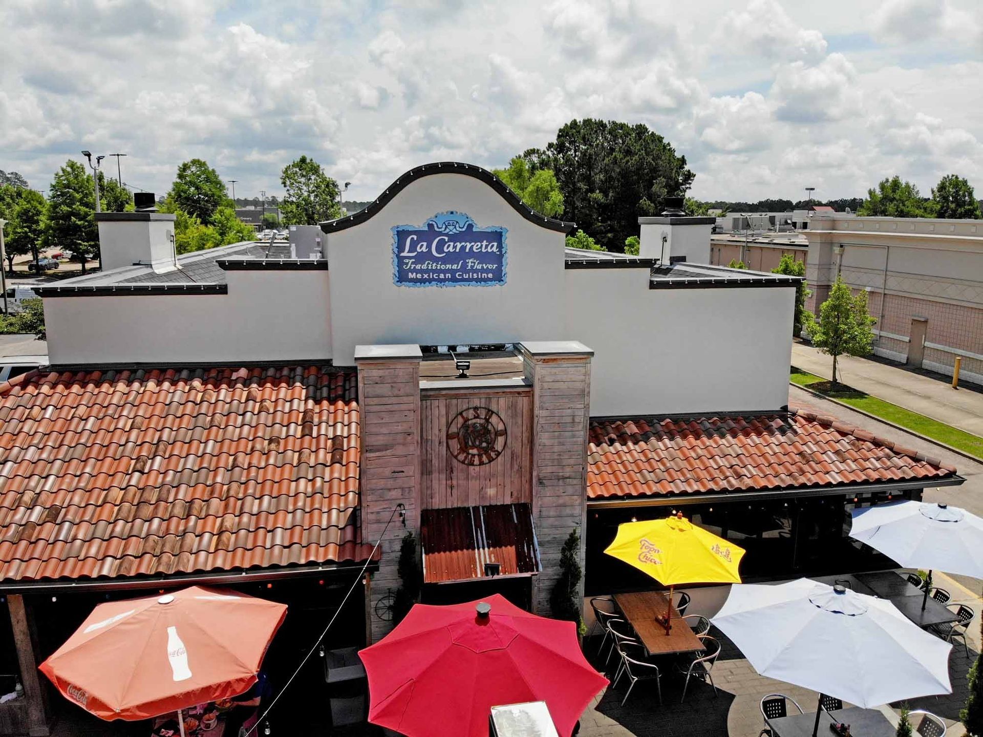 Mexican restaurant exterior with outdoor seating and colorful umbrellas.