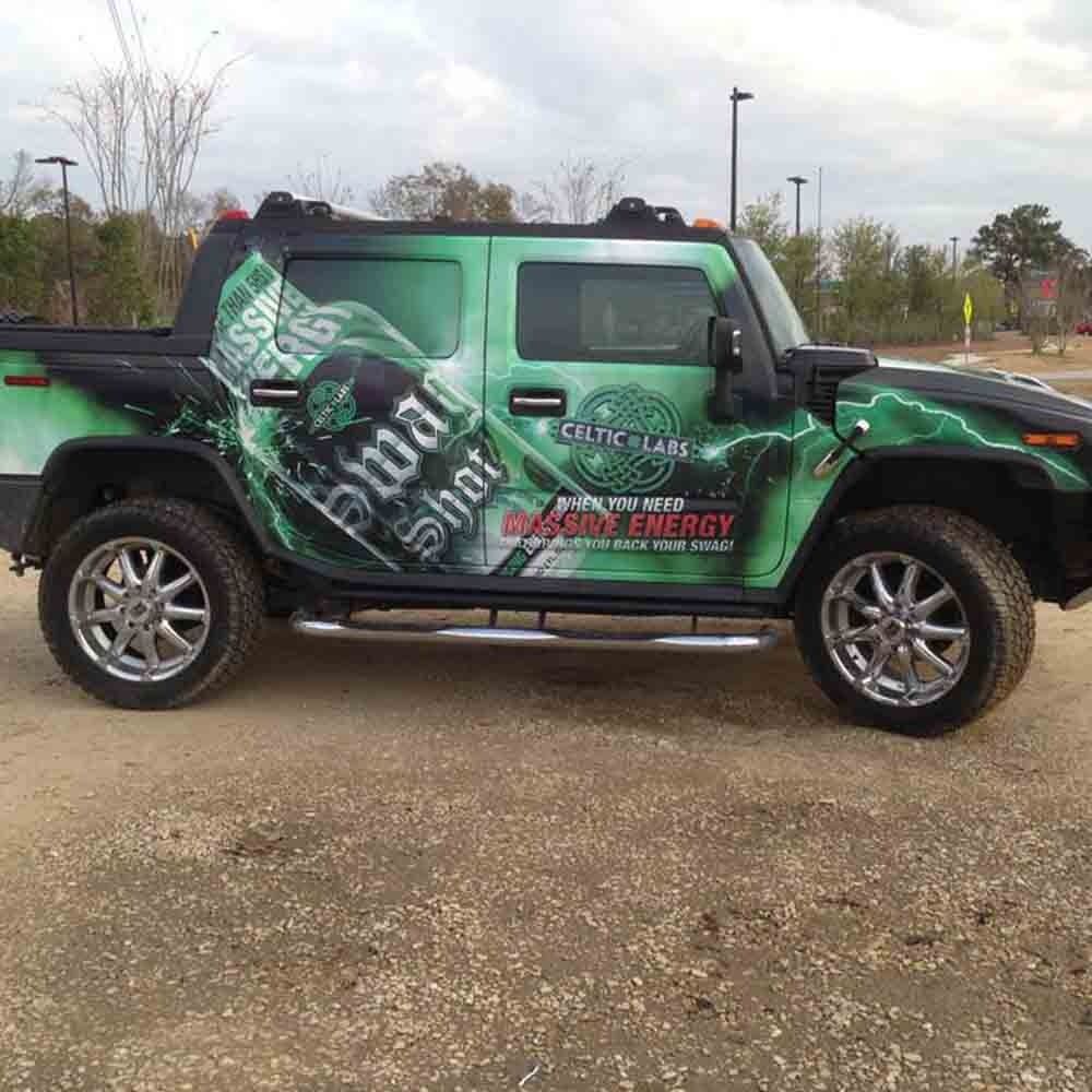 Green and black Hummer H2 with energy drink advertisement.