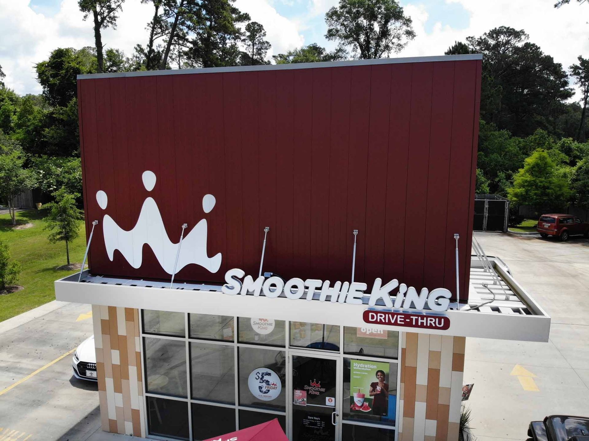 Smoothie King restaurant with a burgundy facade, white logo, and drive-thru sign.