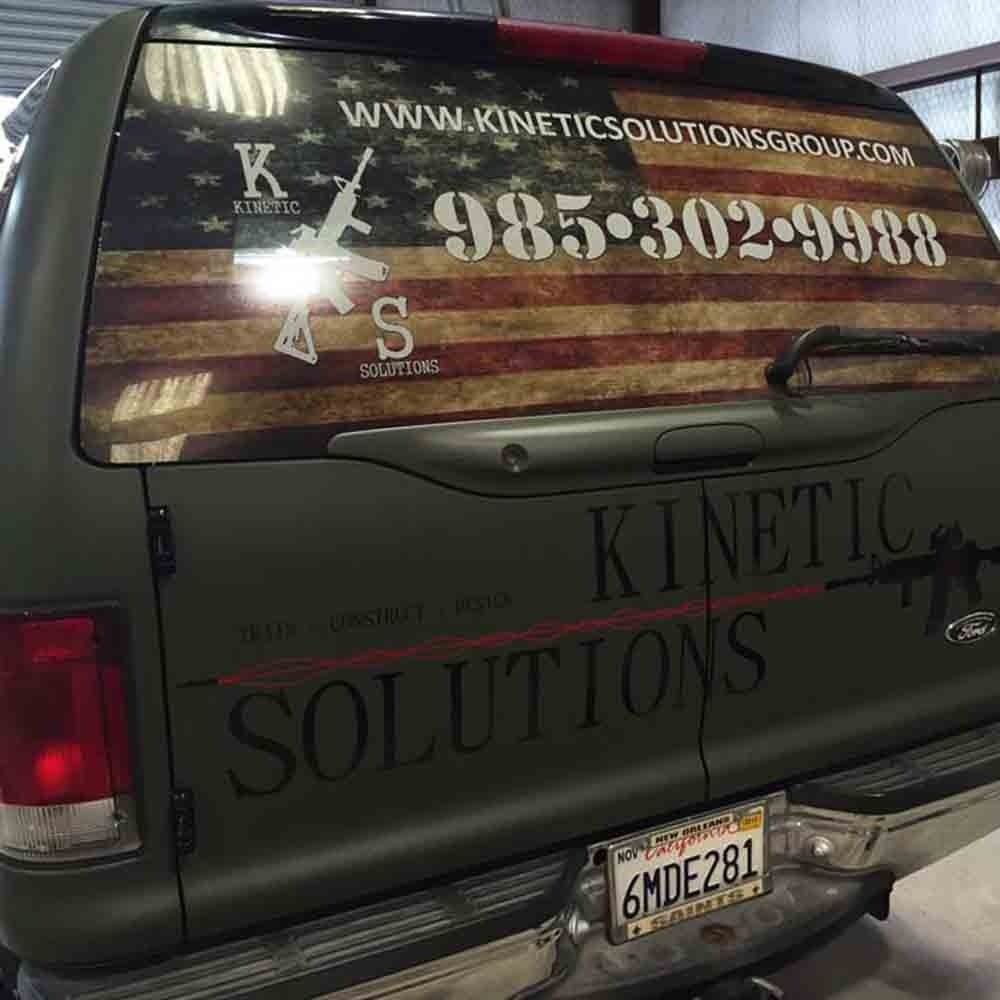 Green SUV with American flag and Kinetic Solutions advertisement.