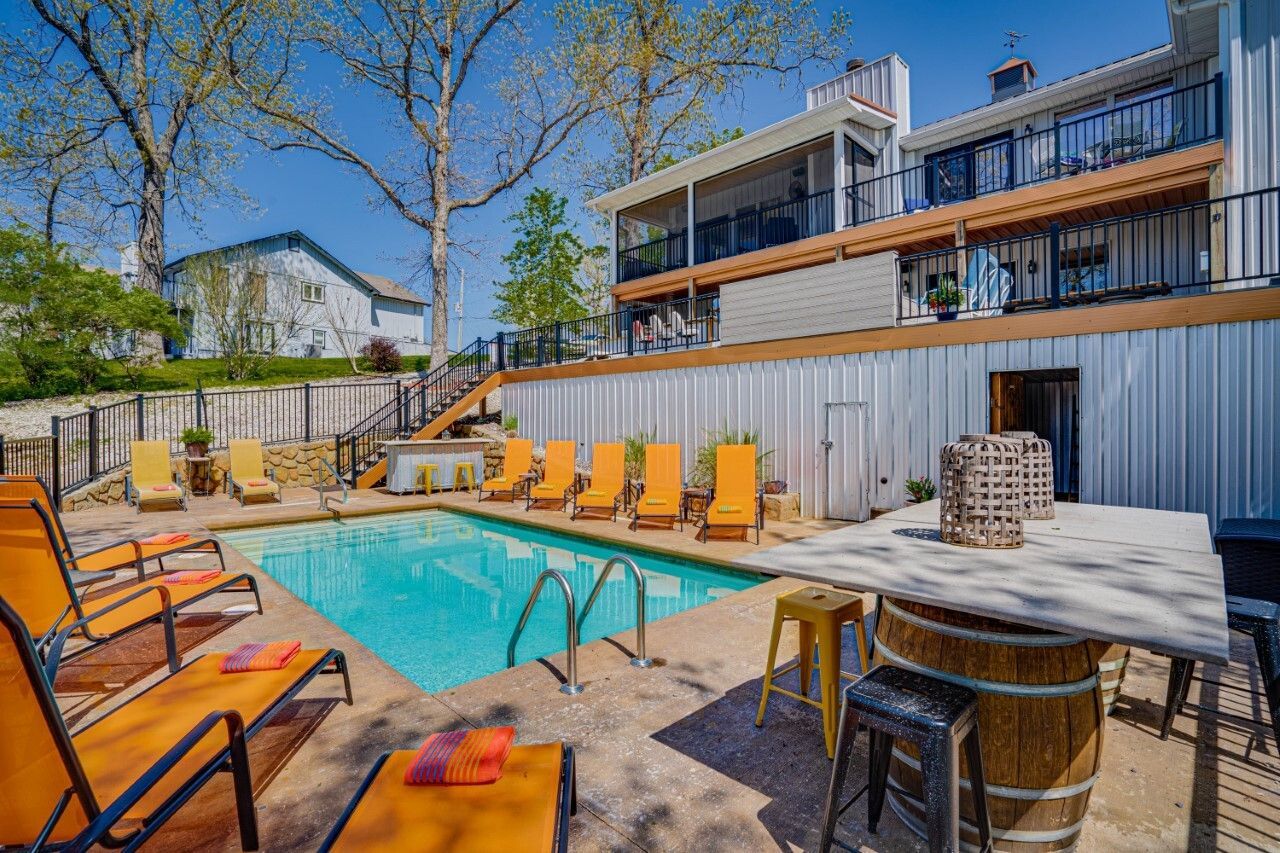 A large swimming pool surrounded by chairs and a table.