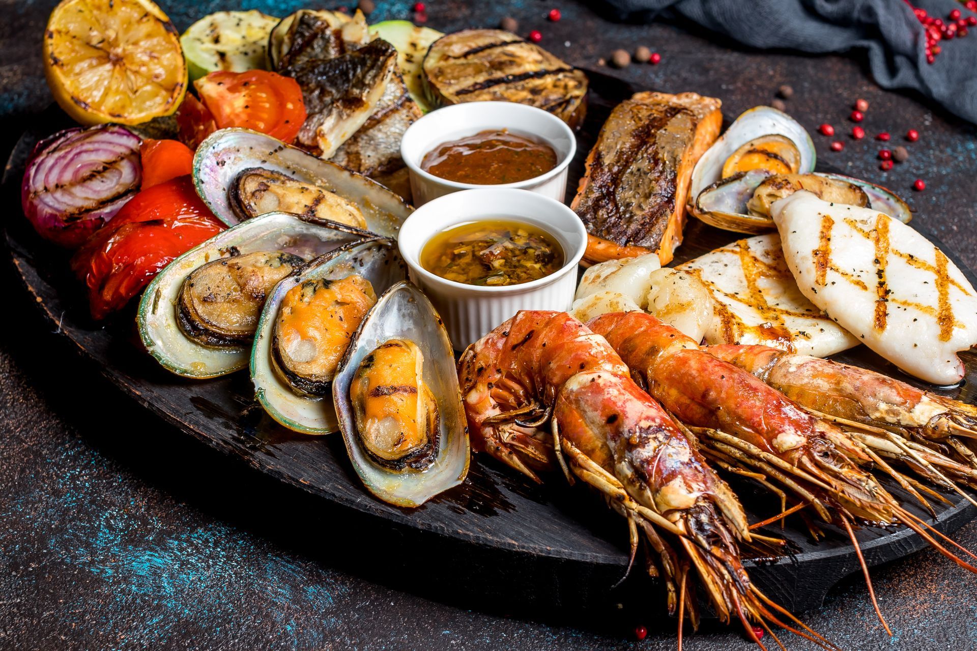 A plate of grilled seafood and vegetables on a table.